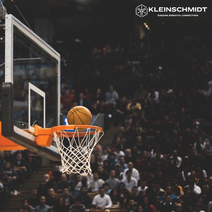 Basketball being shot into basket with Kleinschmidt logo in background